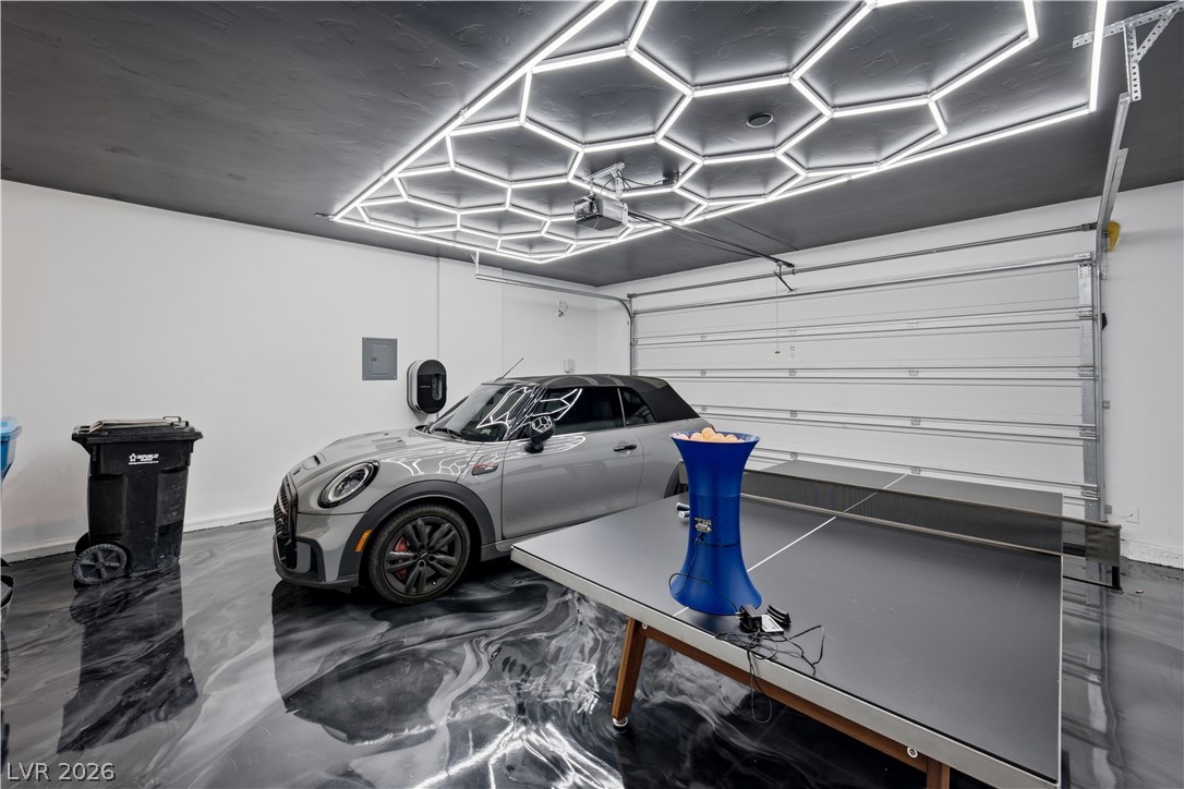 9719 Starlight Ridge Avenue Las Vegas, NV 89148 - Photo 20 of 27 A striking epoxy floor and dynamic hexagonal lighting create an exciting garage atmosphere.