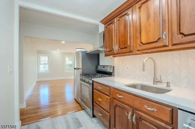 a kitchen with stainless steel appliances granite countertop a sink a stove and cabinets