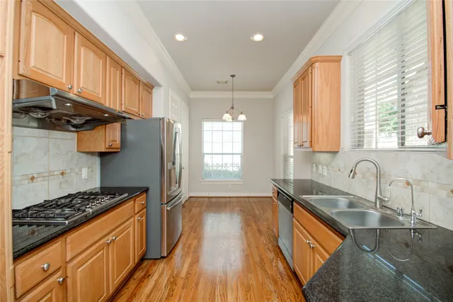 a kitchen with stainless steel appliances granite countertop a refrigerator and a stove