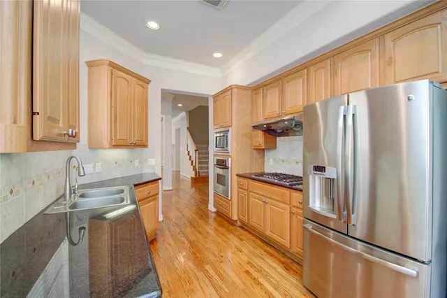 a kitchen with stainless steel appliances granite countertop a stove a sink and a refrigerator