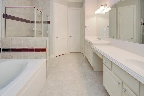 a bathroom with a tub a sink and mirror
