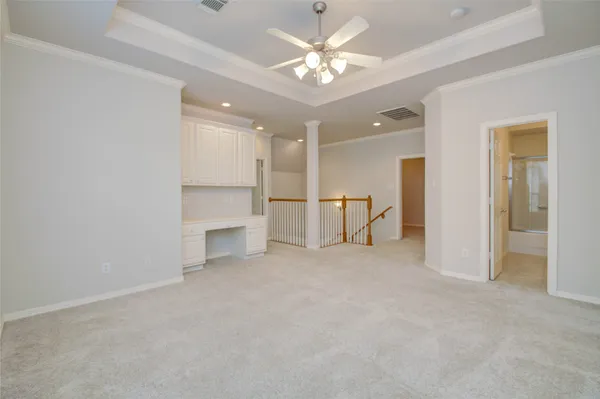 an empty room with windows and chandelier fan