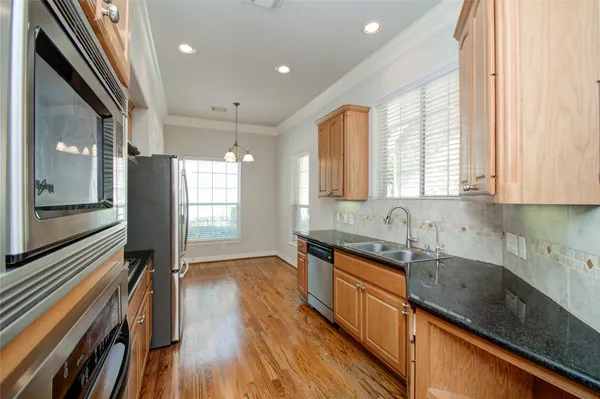 a kitchen with stainless steel appliances granite countertop a sink stove and refrigerator