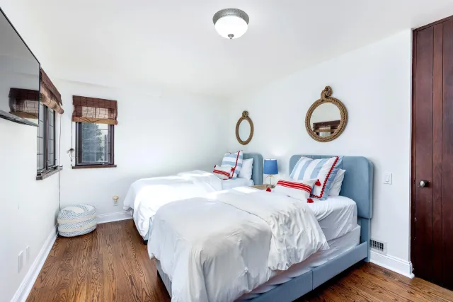 a bedroom with bed and wooden floor