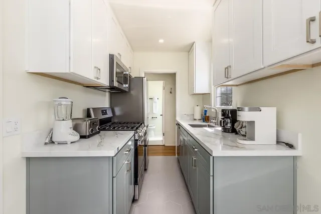 a kitchen with kitchen island a sink stove top oven and cabinets