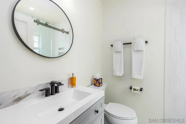a bathroom with a sink a toilet and a mirror