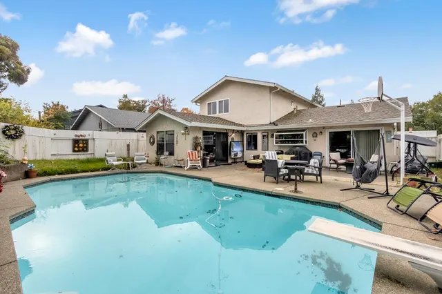 a view of a house with swimming pool and sitting area