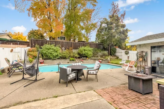 a view of a patio with a dining table and chairs with a fire pit