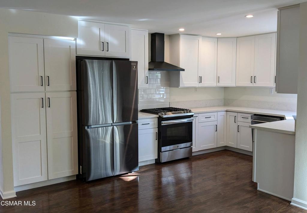 2501 Radford Court Simi Valley, CA 93063 - Photo 9 of 21 a kitchen with a refrigerator stainless steel appliances wooden floor and cabinets