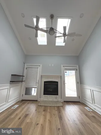 an empty room with windows and fireplace
