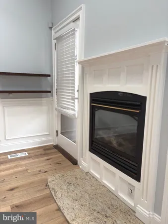 a view of empty room with wooden floor and a fireplace