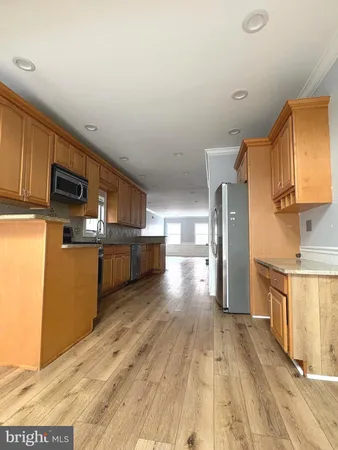 a kitchen with stainless steel appliances wooden floors and wooden cabinets