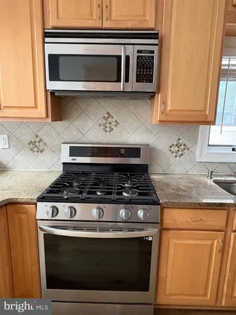 a stove top oven sitting inside of a kitchen