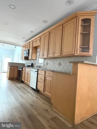 a kitchen with granite countertop wooden cabinets a sink and dishwasher