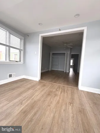 a view of a livingroom with wooden floor and a ceiling fan