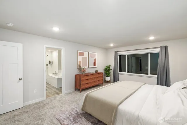 a bedroom with a large bed and windows