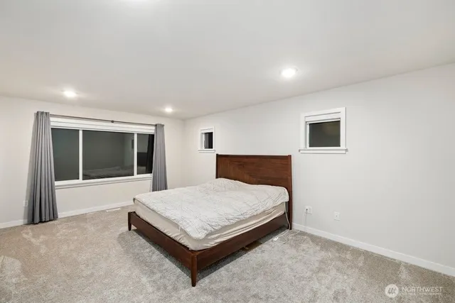 a spacious bedroom with a bed and a large window