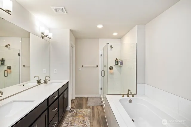 a bathroom with a double vanity sink a mirror and a bathtub