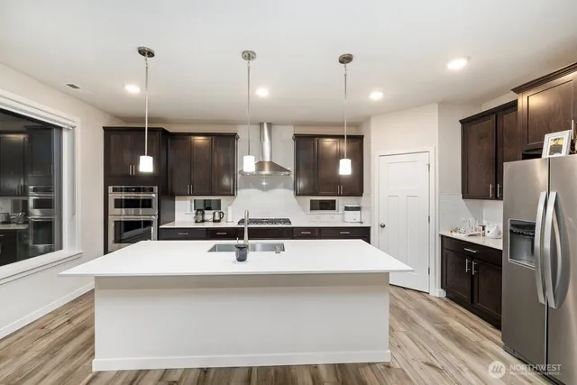 a large kitchen with kitchen island a sink stainless steel appliances and cabinets