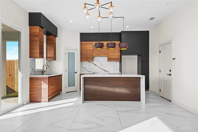 a view of kitchen with stainless steel appliances kitchen island granite countertop a stove a sink and a microwave