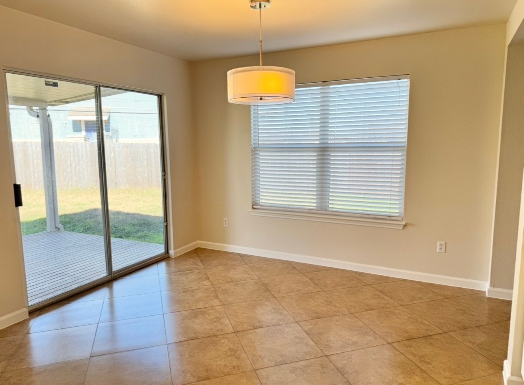 110 Comal Cove Elgin, TX 78621 - Photo 11 of 25 Spare room featuring plenty of natural light and light tile patterned floors