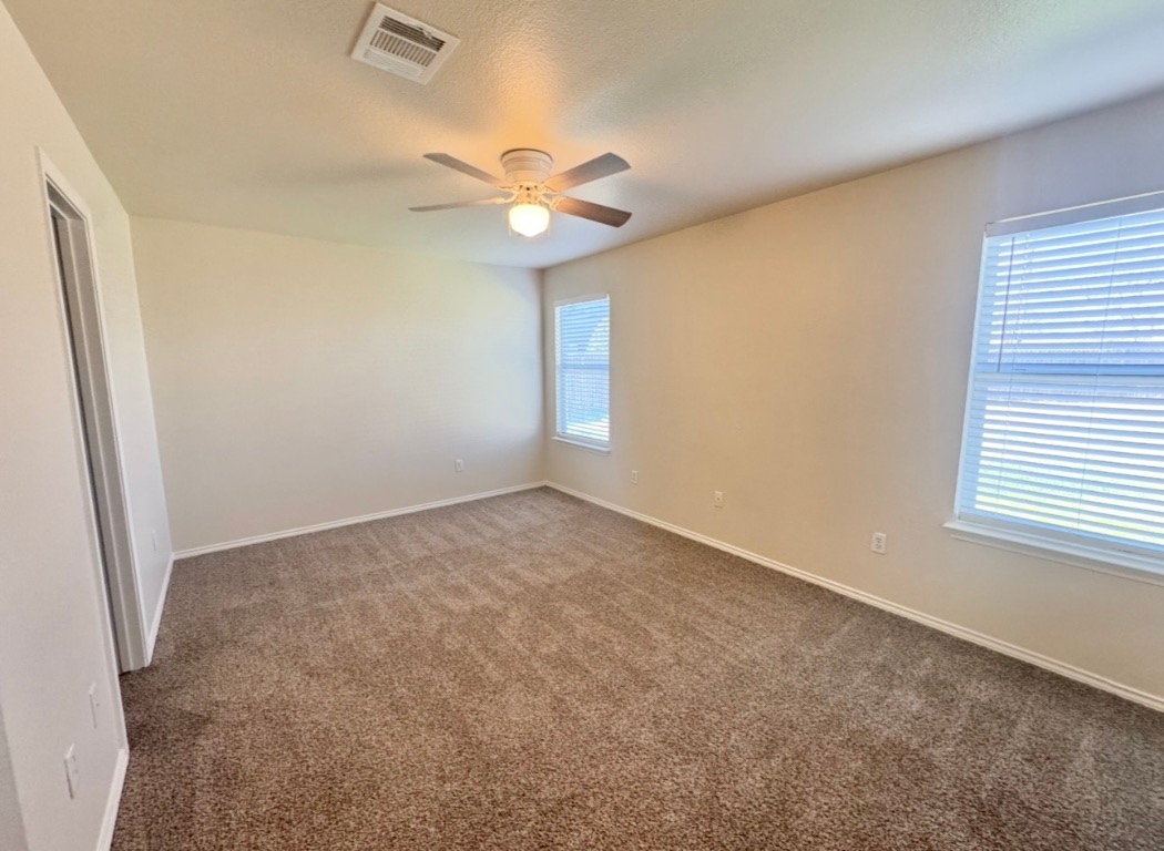 110 Comal Cove Elgin, TX 78621 - Photo 12 of 25 Carpeted empty room with ceiling fan and a textured ceiling