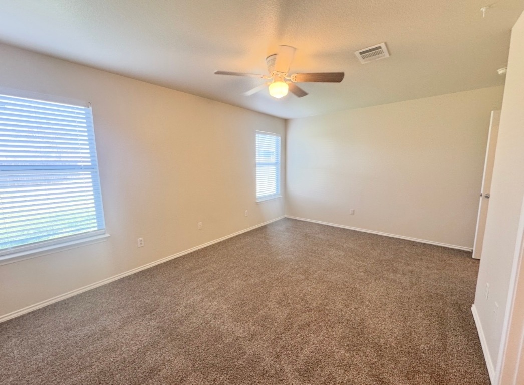 110 Comal Cove Elgin, TX 78621 - Photo 13 of 25 Empty room with dark colored carpet, a textured ceiling, and ceiling fan