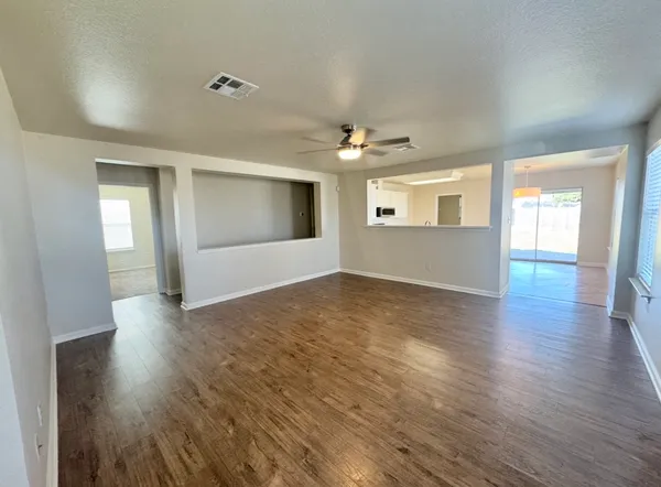 an empty room with wooden floor and windows