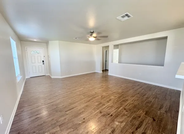 wooden floor in an empty room with a window