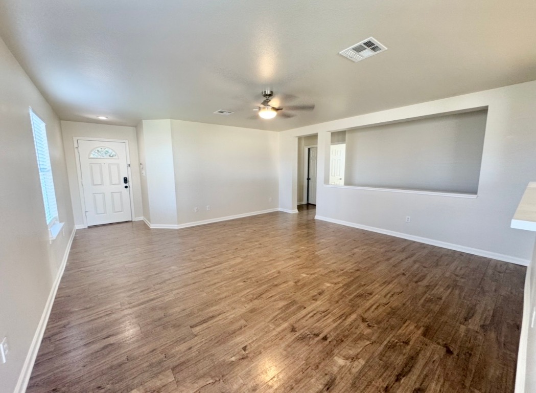 110 Comal Cove Elgin, TX 78621 - Photo 5 of 25 Unfurnished room with dark wood-style floors and ceiling fan
