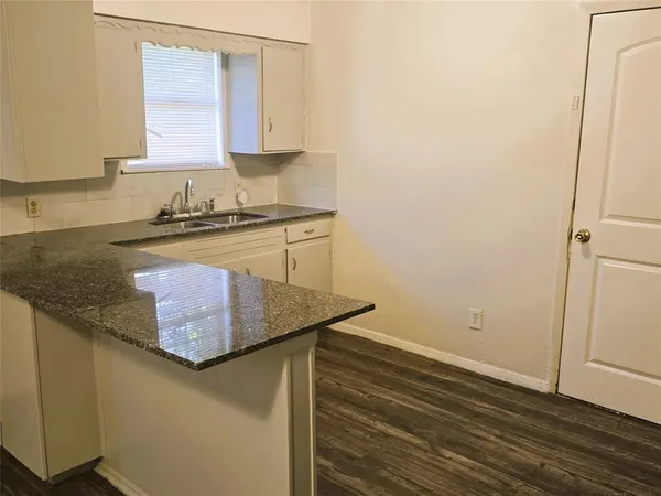 a kitchen with granite countertop a sink and a stove