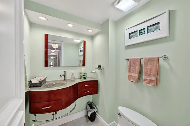 a bathroom with a toilet sink and mirror