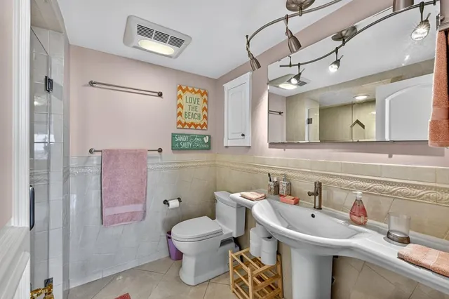 a bathroom with a sink and mirror with toilet