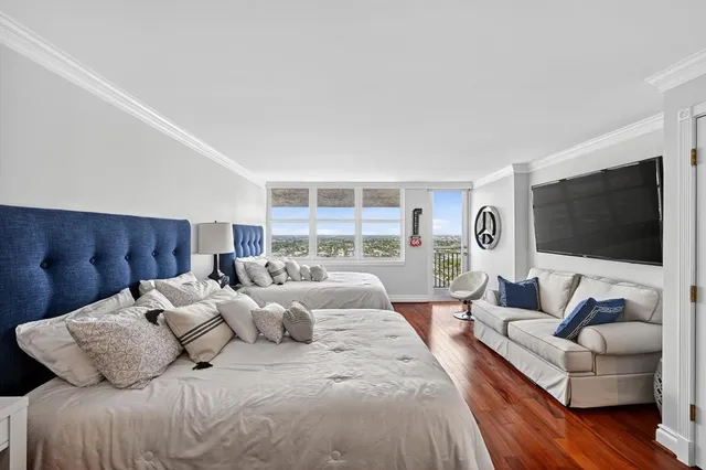 a bedroom with two beds and a large mirror with wooden floor