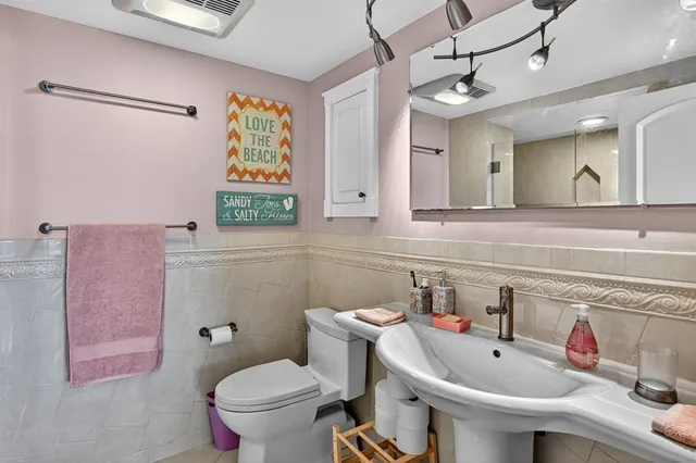 a bathroom with a sink and mirror with toilet