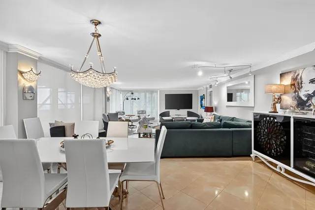 a view of a dining room and livingroom with furniture wooden floor a chandelier