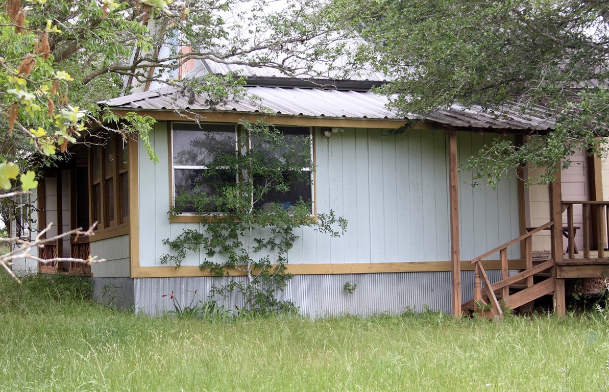 7887 Pettytown Road Red Rock, TX 78662 - Photo 12 of 26 a backyard of a house with lots of green space