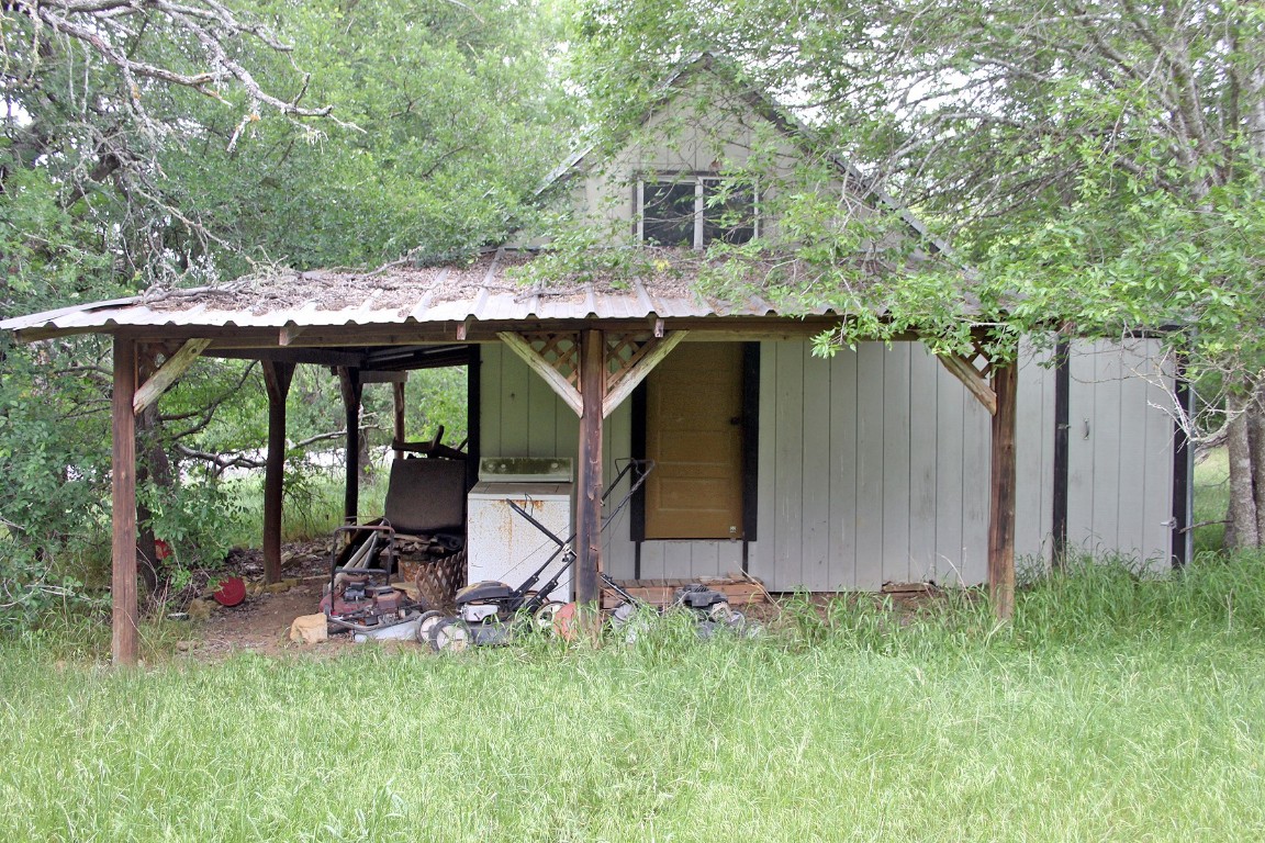 7887 Pettytown Road Red Rock, TX 78662 - Photo 19 of 26 a view of backyard with a barn and a large cactus tree