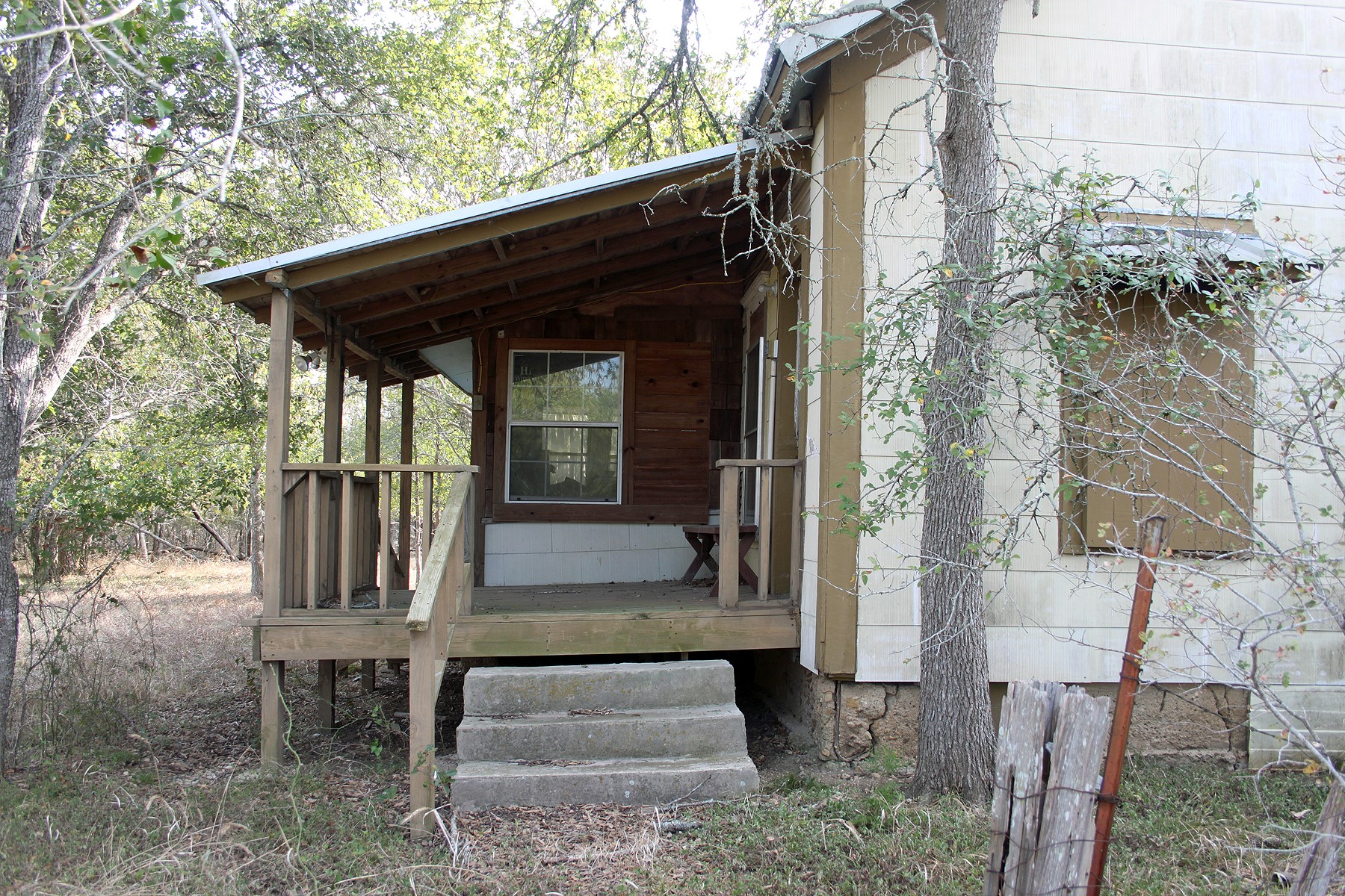 7887 Pettytown Road Red Rock, TX 78662 - Photo 3 of 26 a view of house with wooden fence and a bench