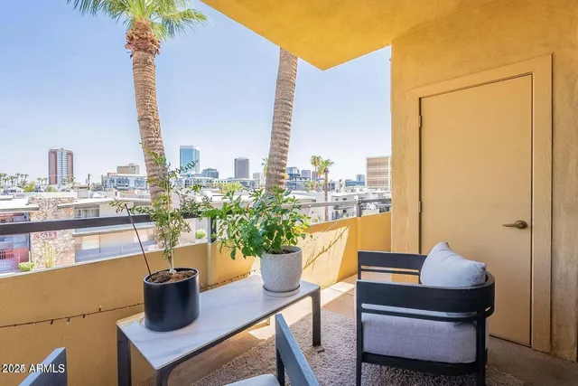 a view of a balcony with chairs and a potted plant