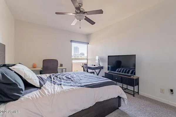 a bedroom with a bed desk and a window