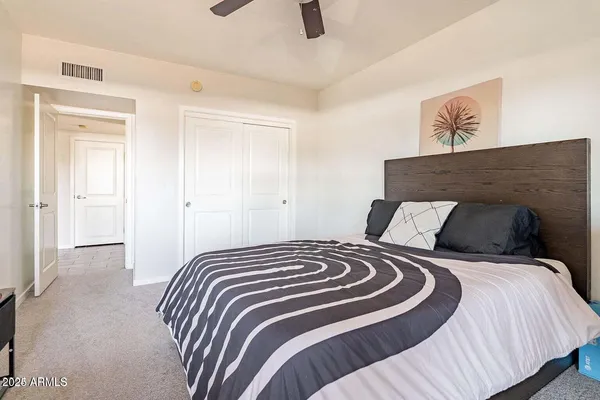 a bedroom with a bed and painting on the wall