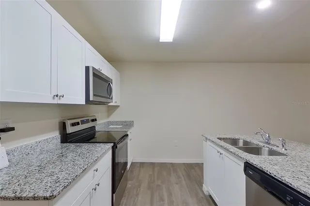 a kitchen with stainless steel appliances granite countertop a sink stove and microwave