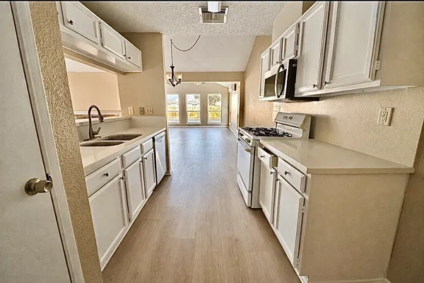 a kitchen with stainless steel appliances a stove a sink and a refrigerator