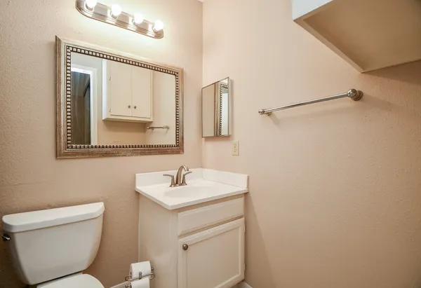 a bathroom with a toilet sink and mirror