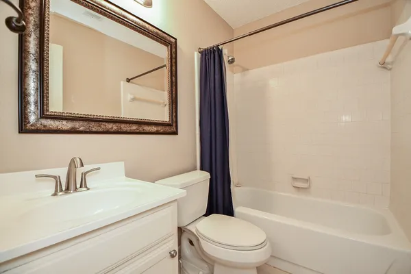 a bathroom with a sink a mirror a toilet and bathtub
