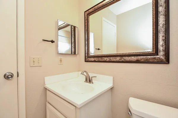 a bathroom with a toilet sink and mirror