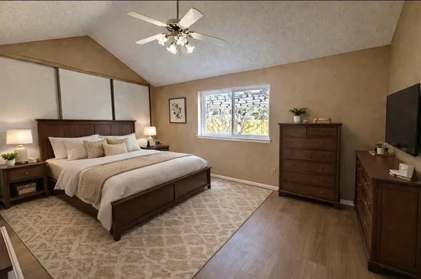 a bedroom with a bed and a flat tv screen on dresser