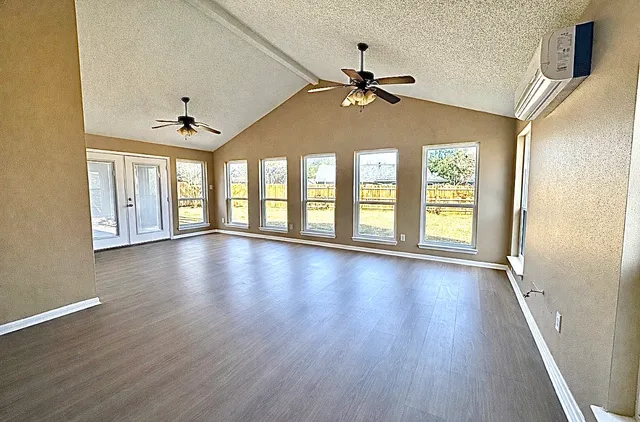a view of an room with wooden floor fan and windows