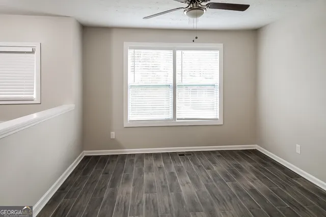 a view of a room with wooden floor and windows